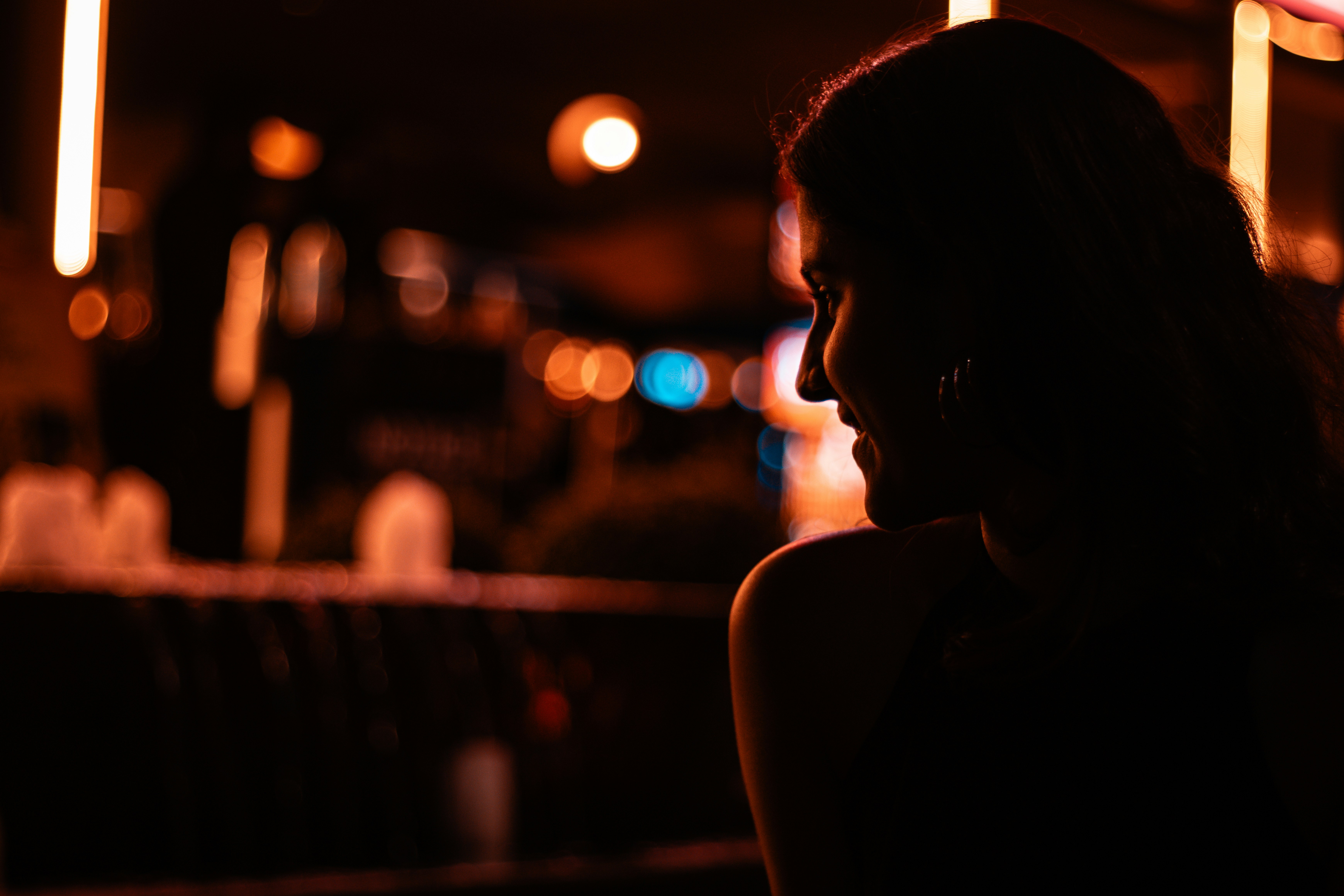 Woman's silhouette in a dimly lit, blurred scene.