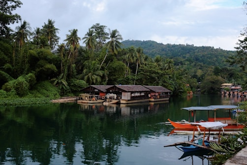 Scenic river with boats and lush greenery surrounds.