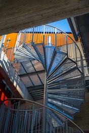 Spiral staircase against colorful building's wall.