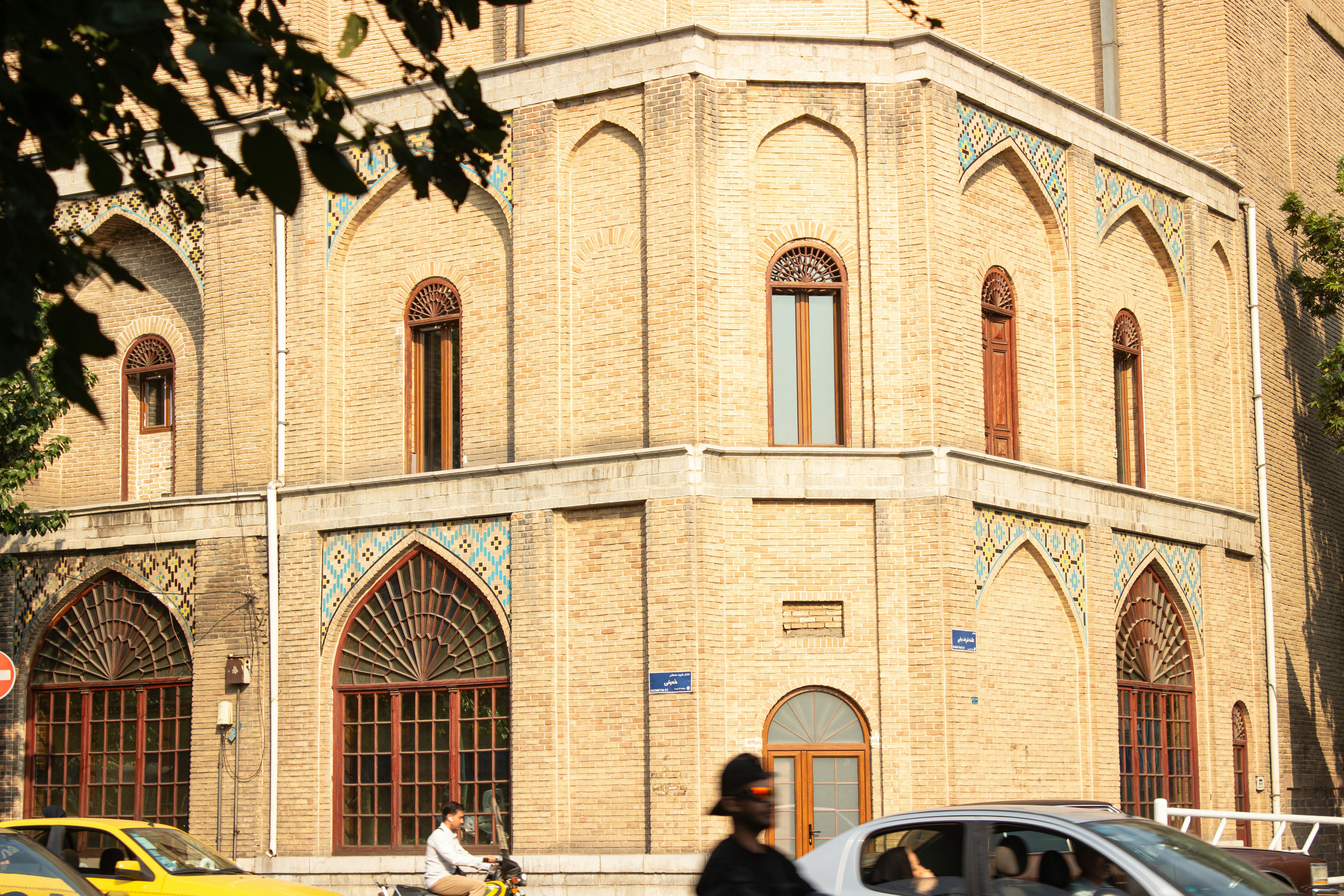 Corner of an ornate building with arched windows.