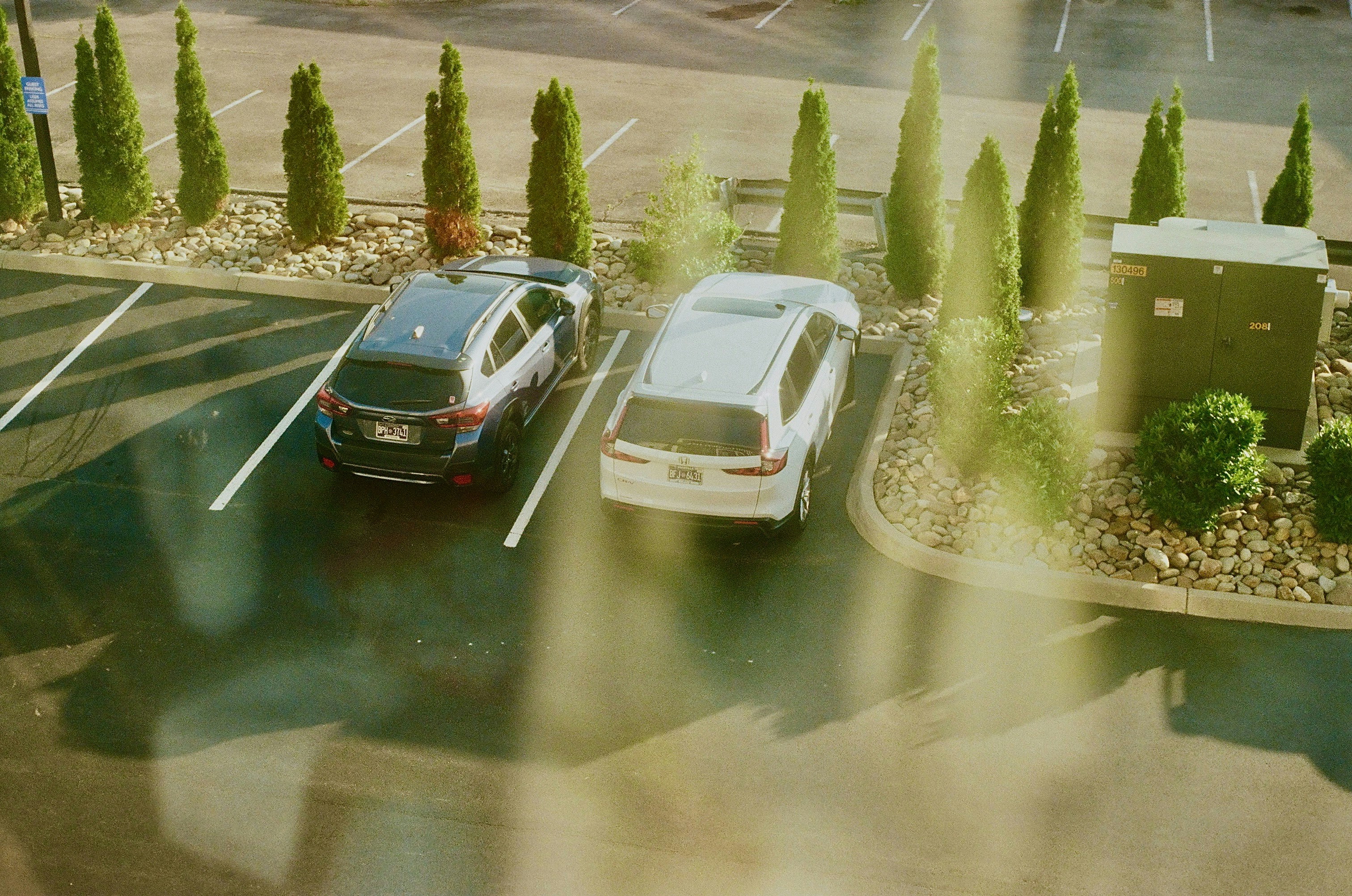 Two cars are parked in an outdoor parking lot.