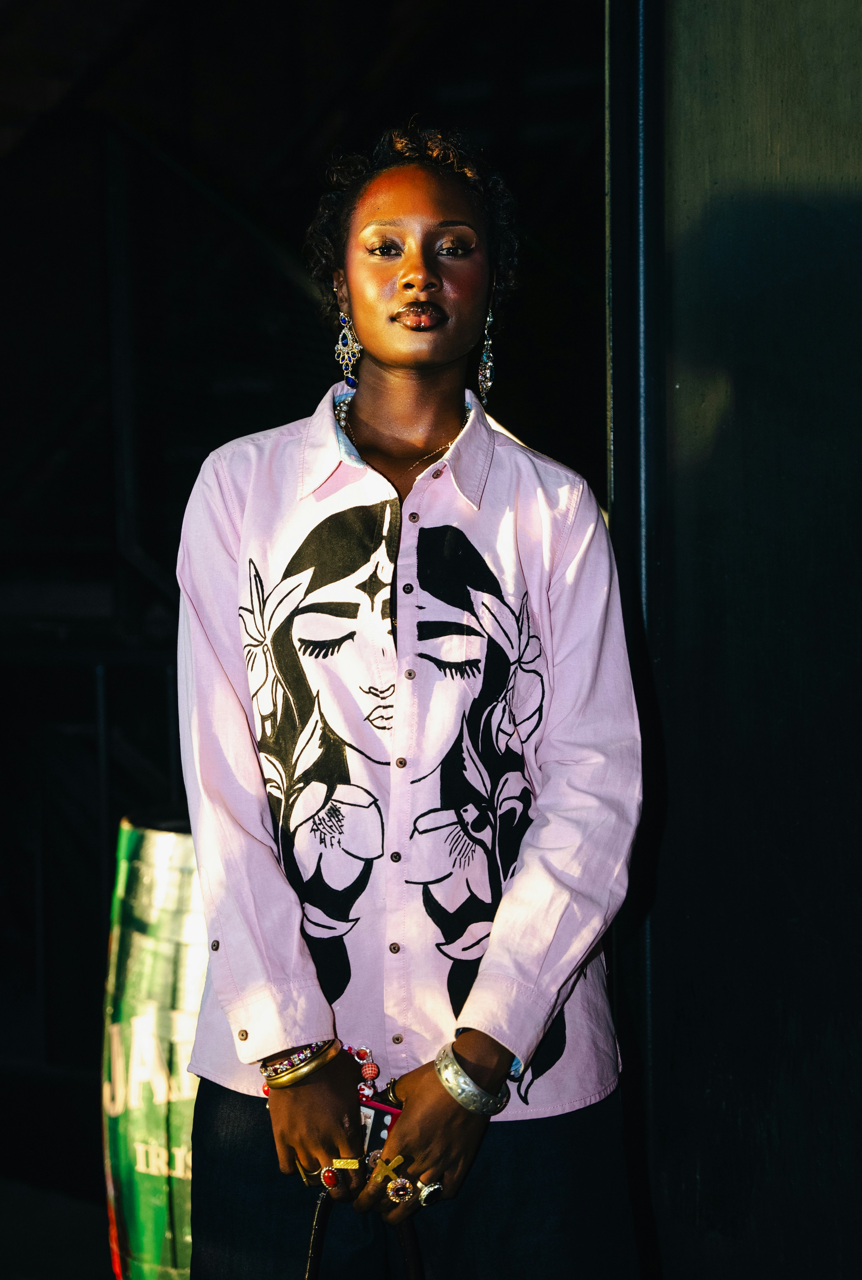 Una mujer elegante posa con una camisa rosa.