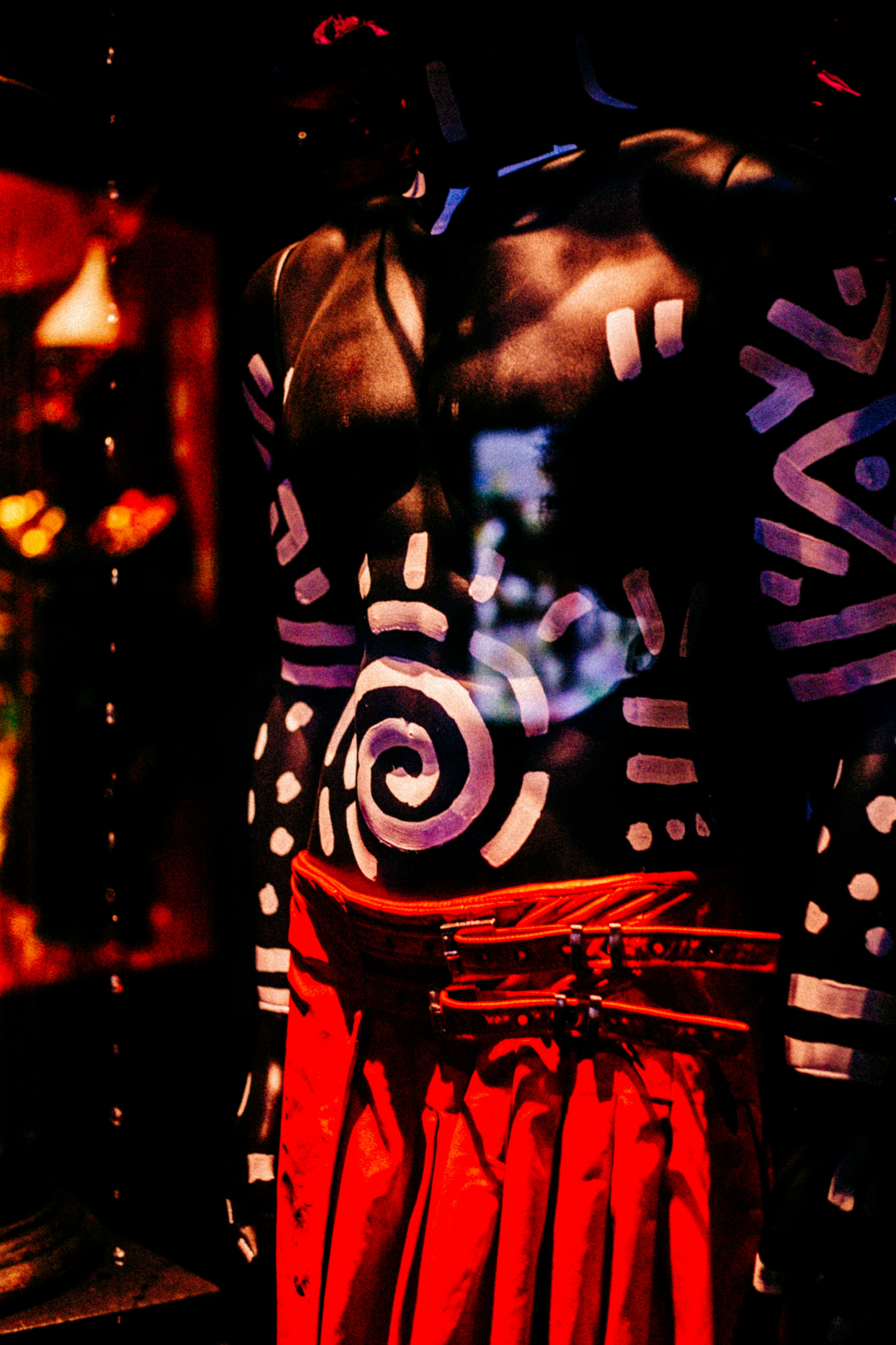 Mannequin wearing tribal body paint and red skirt.