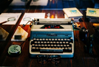 Vintage typewriter sits amidst documents and tools.