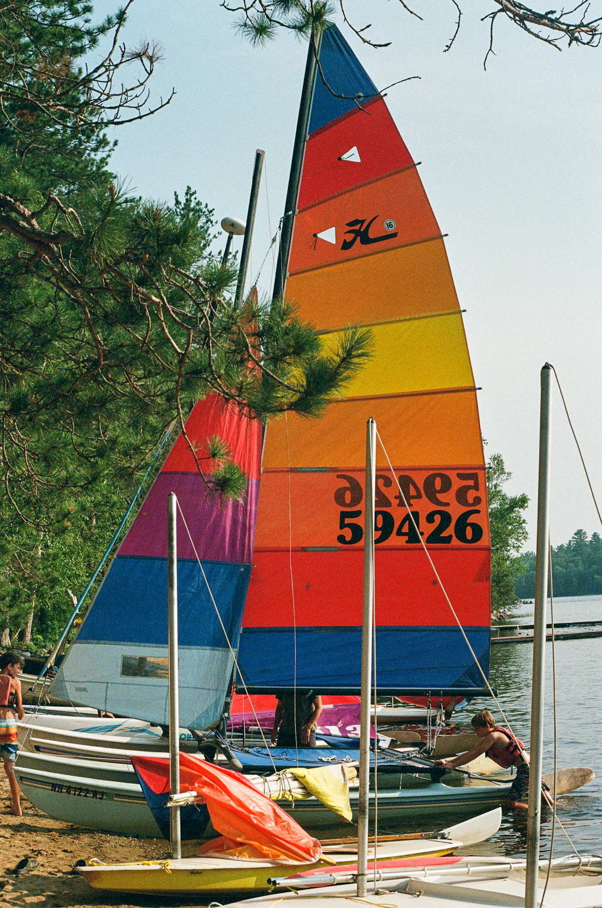 Colorful sailboat sits on a lake shore