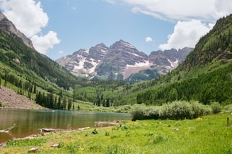 Mountains and lake meet under a sunny sky.