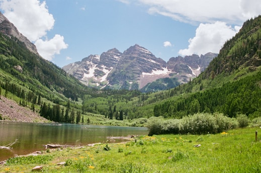 Mountains and lake meet under a sunny sky.