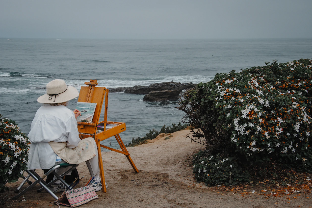 Artist painting a seascape at an easel