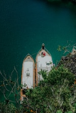 Two boats are anchored in a crystal-clear bay.
