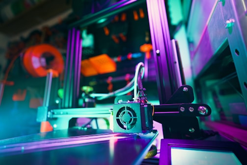 A 3D printer illuminated with colorful lights.