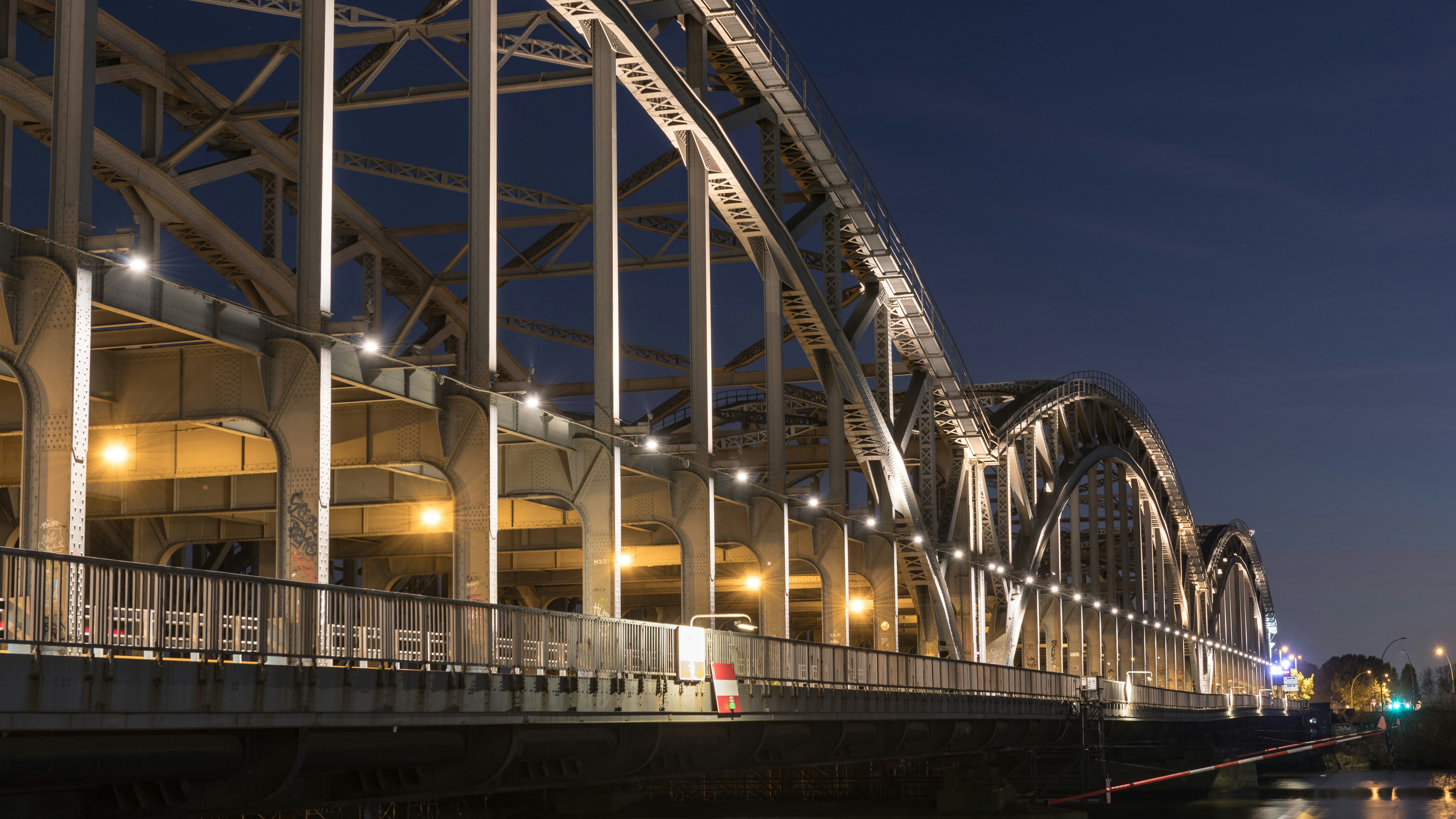 Illuminated bridge at night against a dark sky.