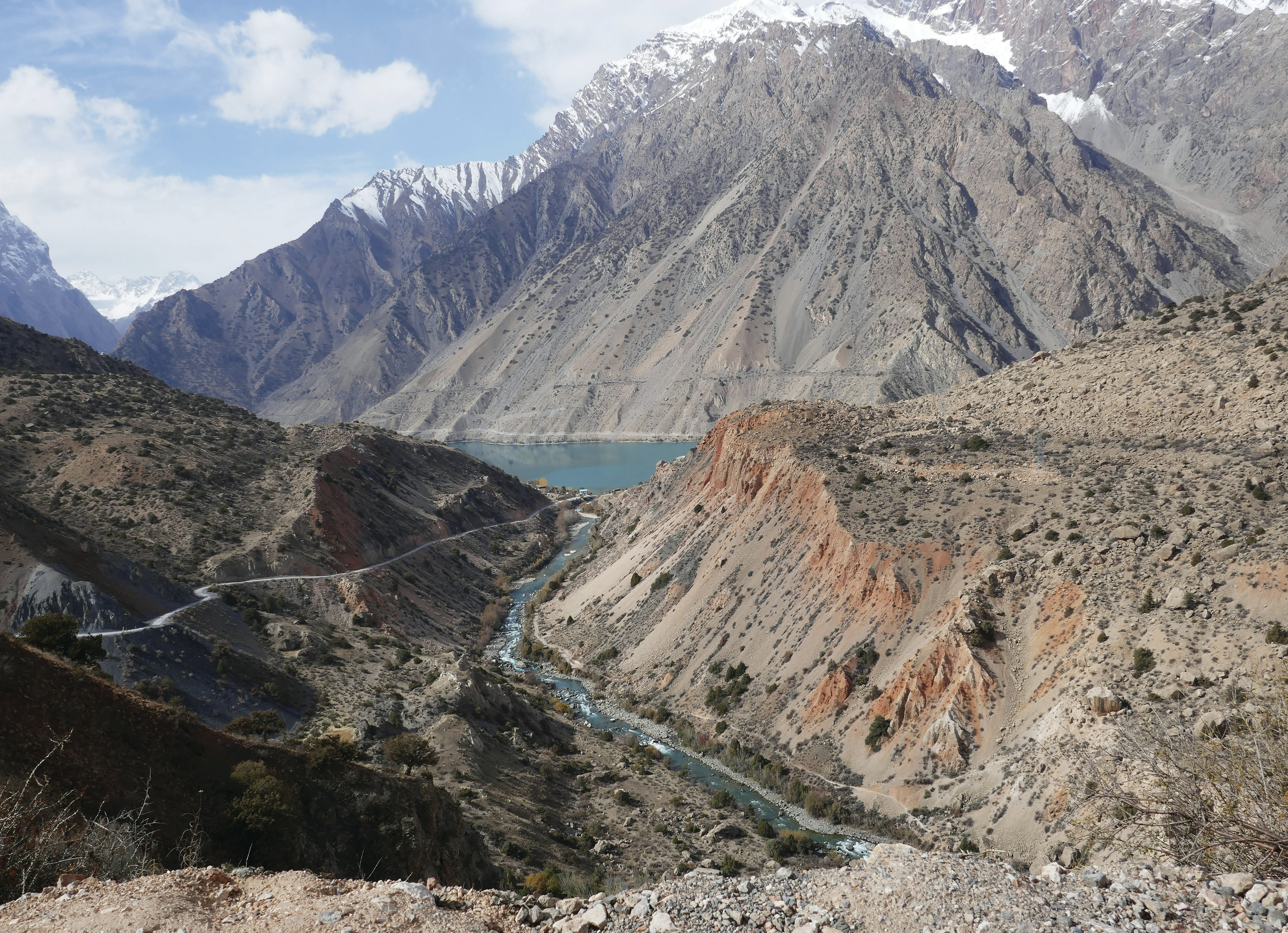 Mountains surround a river and lake in nature.