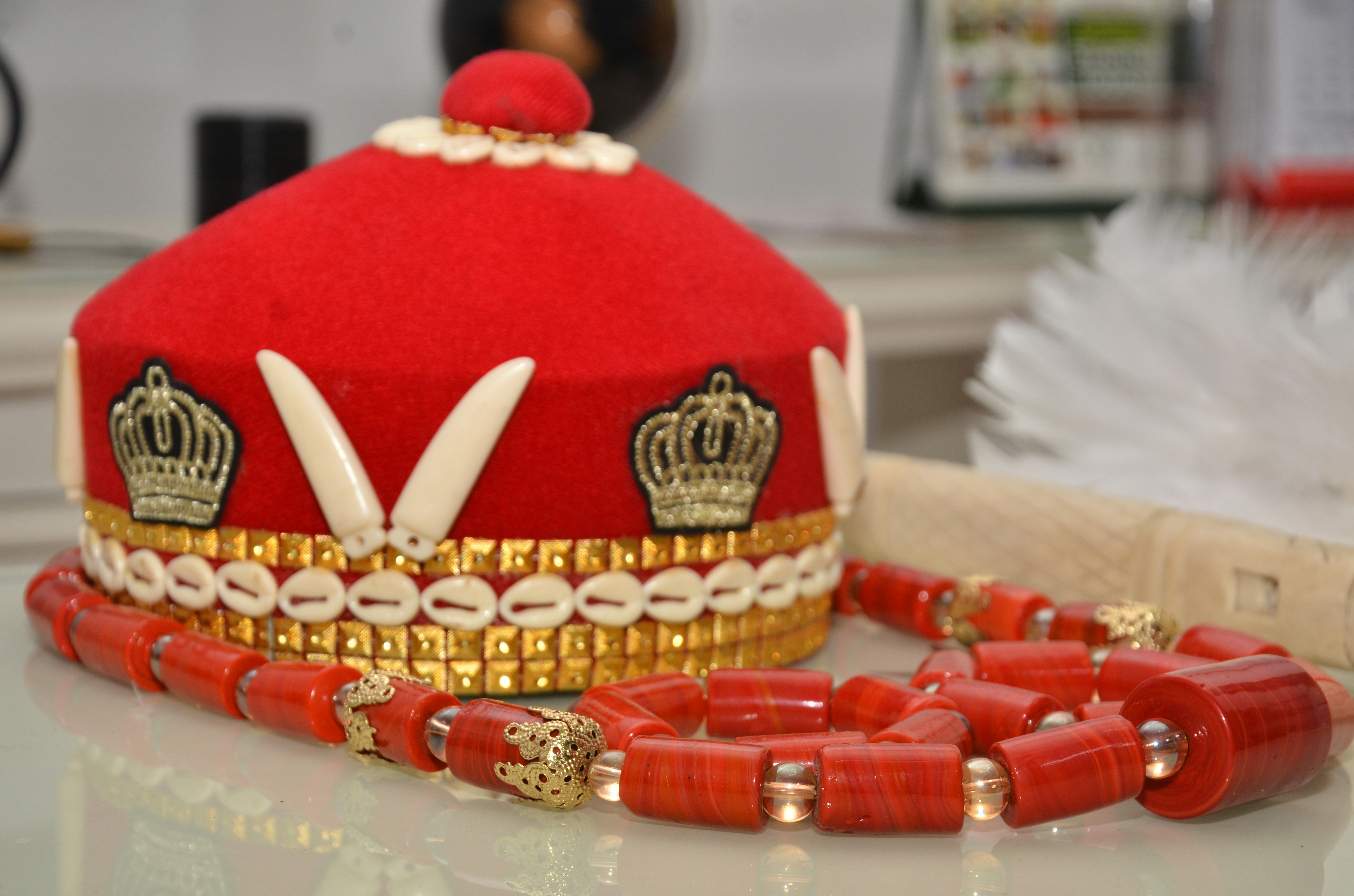 Um chapéu tradicional vermelho e um colar sentam-se juntos.