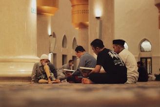 People are reading religious texts in a mosque.