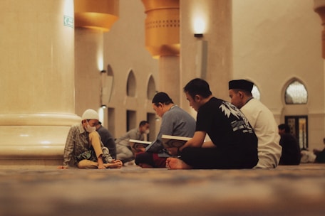 People are reading religious texts in a mosque.