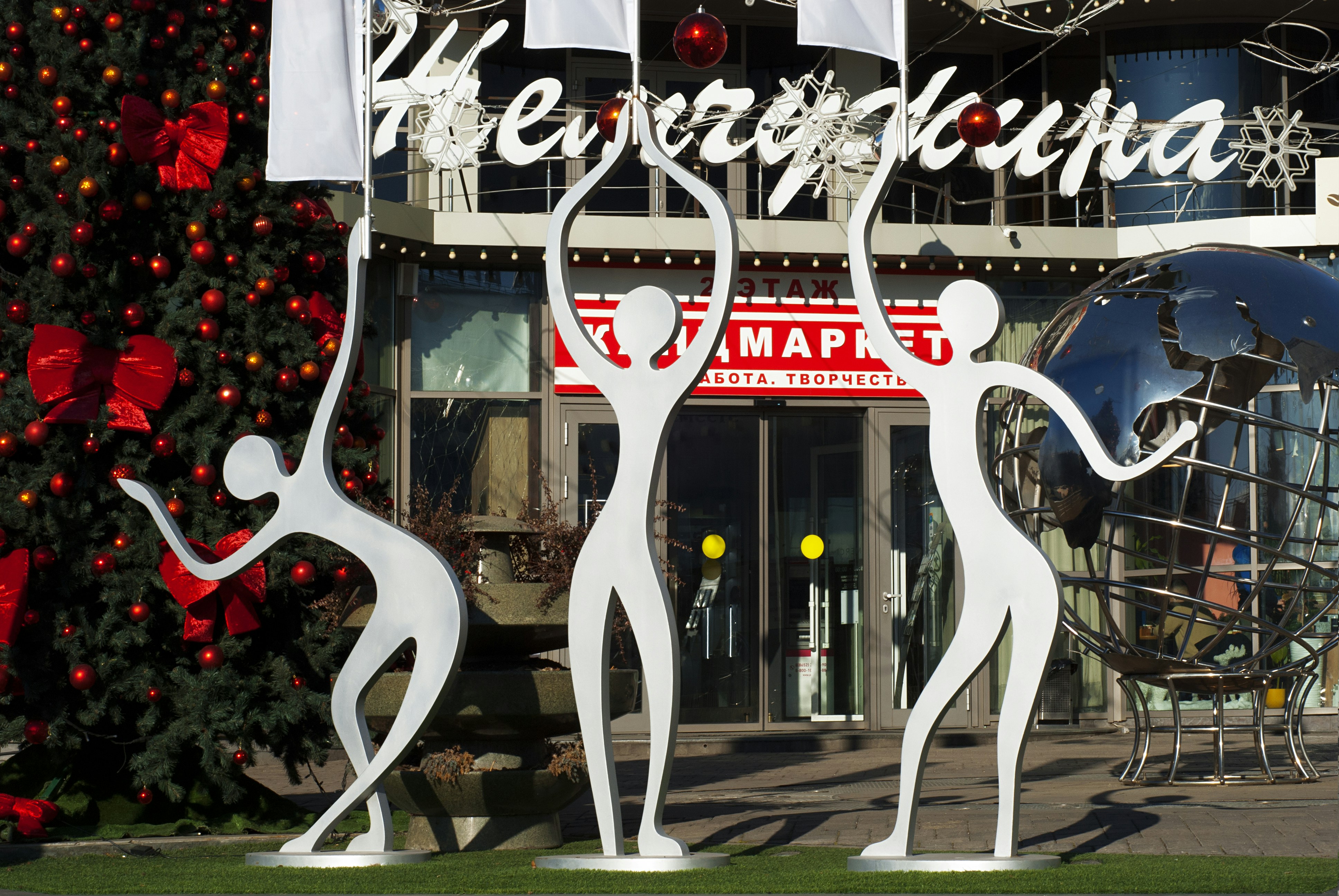 Three white sculptures decorate an entrance.