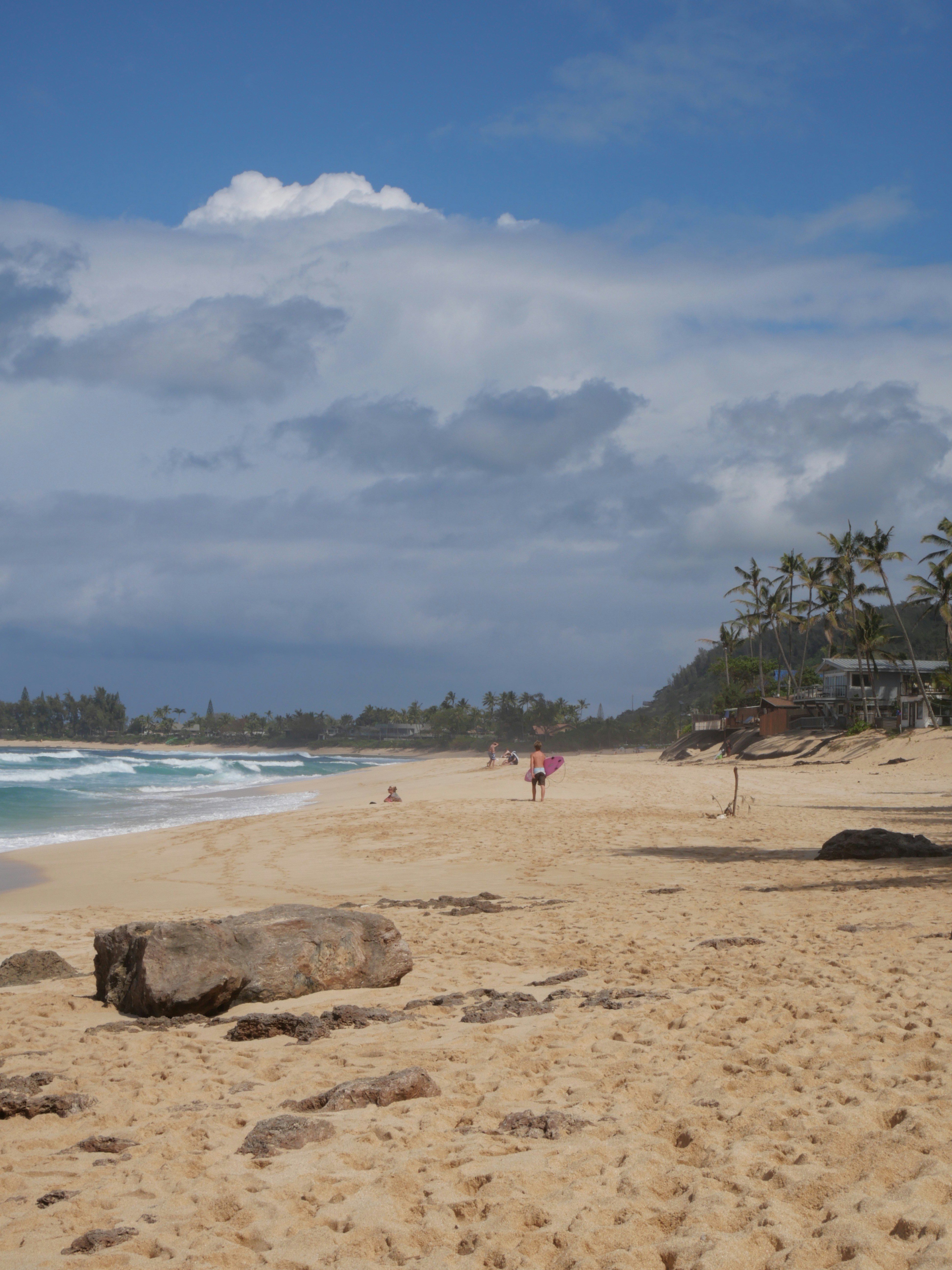 Une belle plage de sable avec un ciel nuageux.