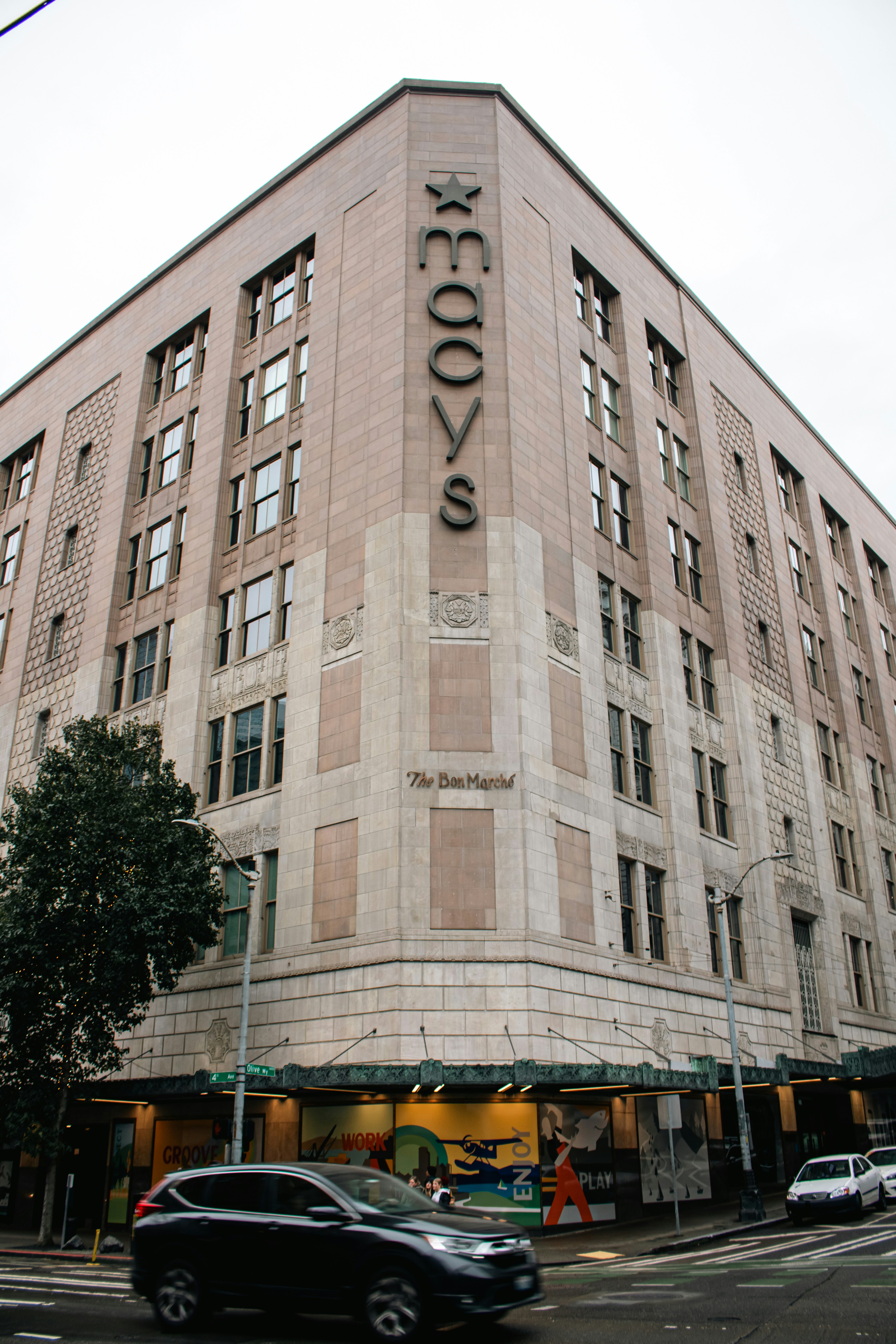 The macy's building stands tall on the city street.