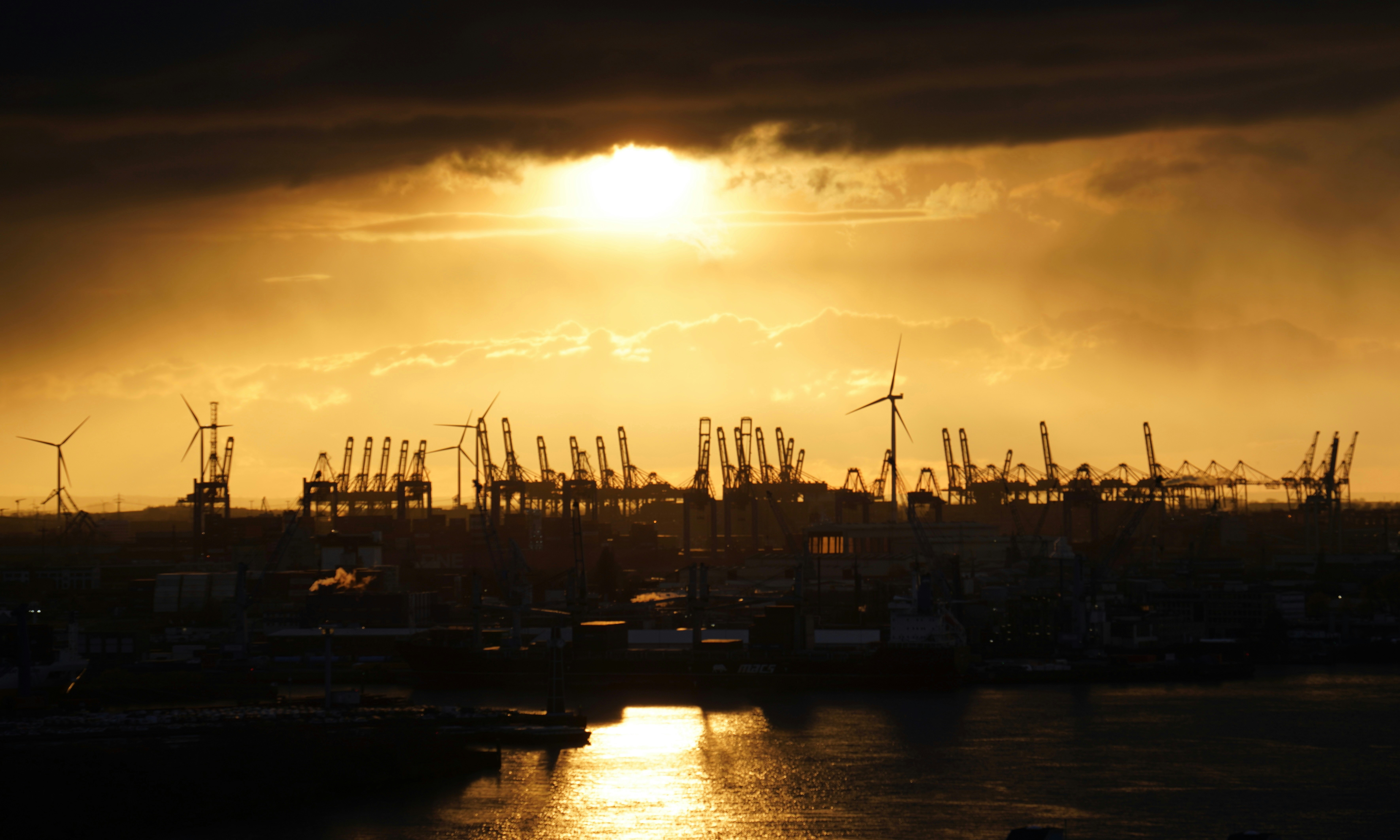 The harbor is silhouetted by a golden sunset.