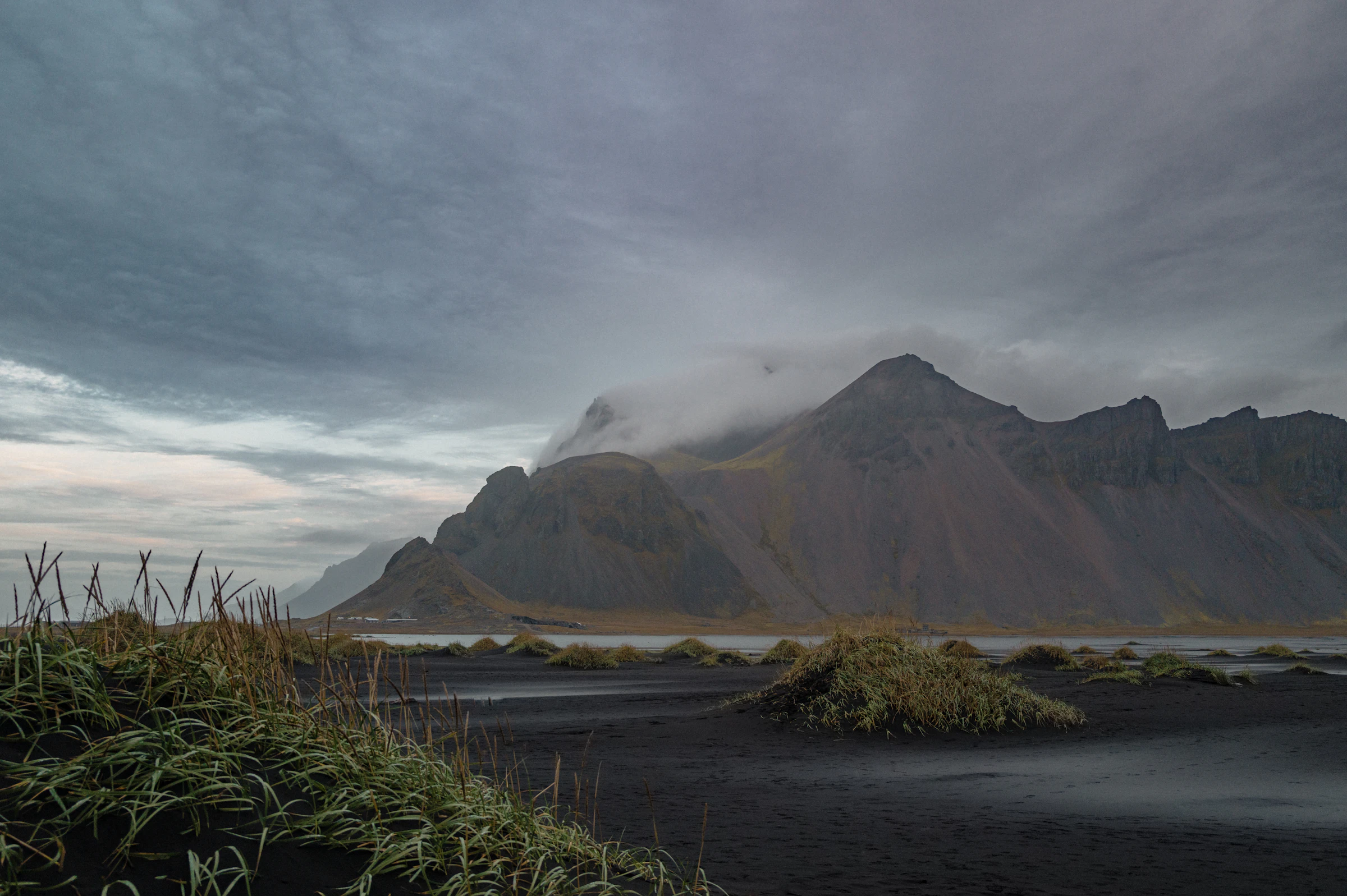 Dramatic mountain ridges silhouetted under a cloudy moody sky
