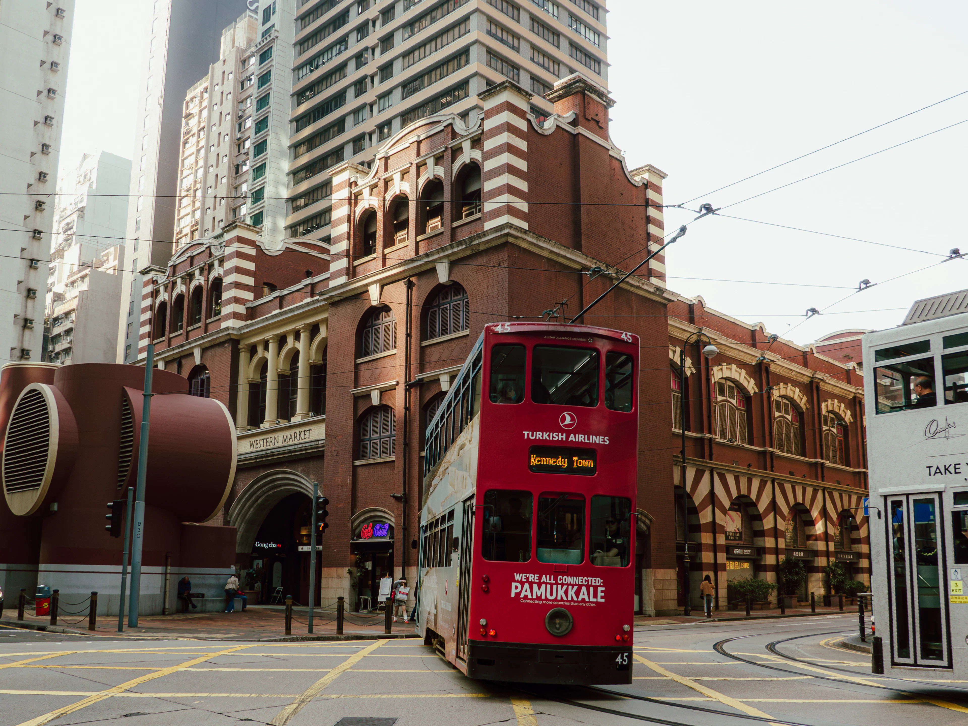 Raudonas dviaukštis tramvajus prie istorinio Western Market pastato Sheung Wan kvartale