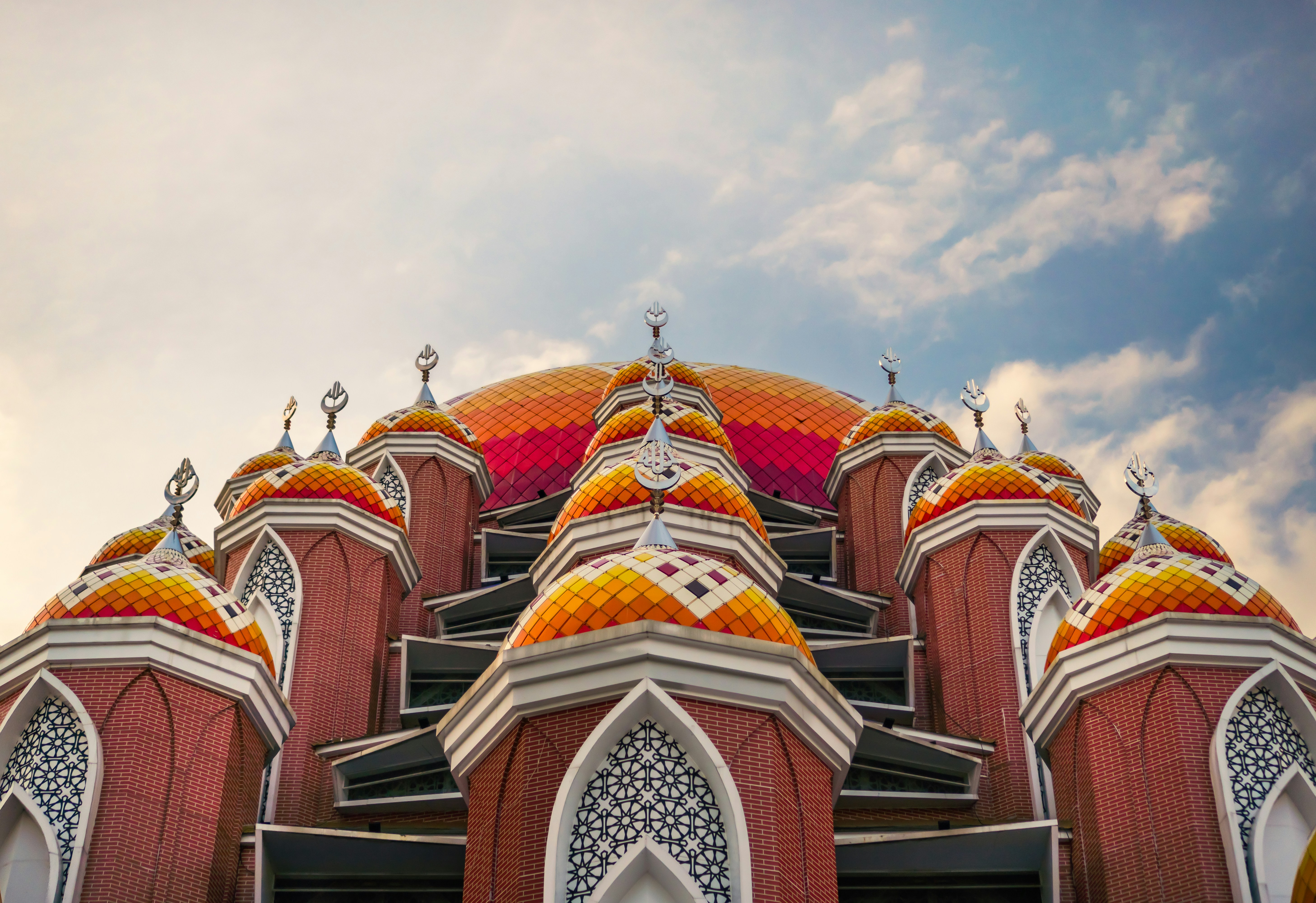A beautiful, colorful mosque against the cloudy sky.