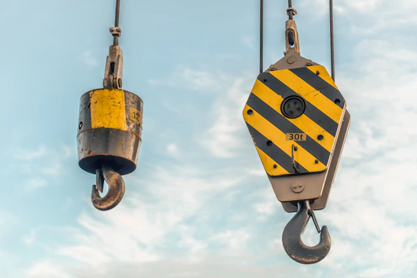 Crane hooks hanging in the sky.