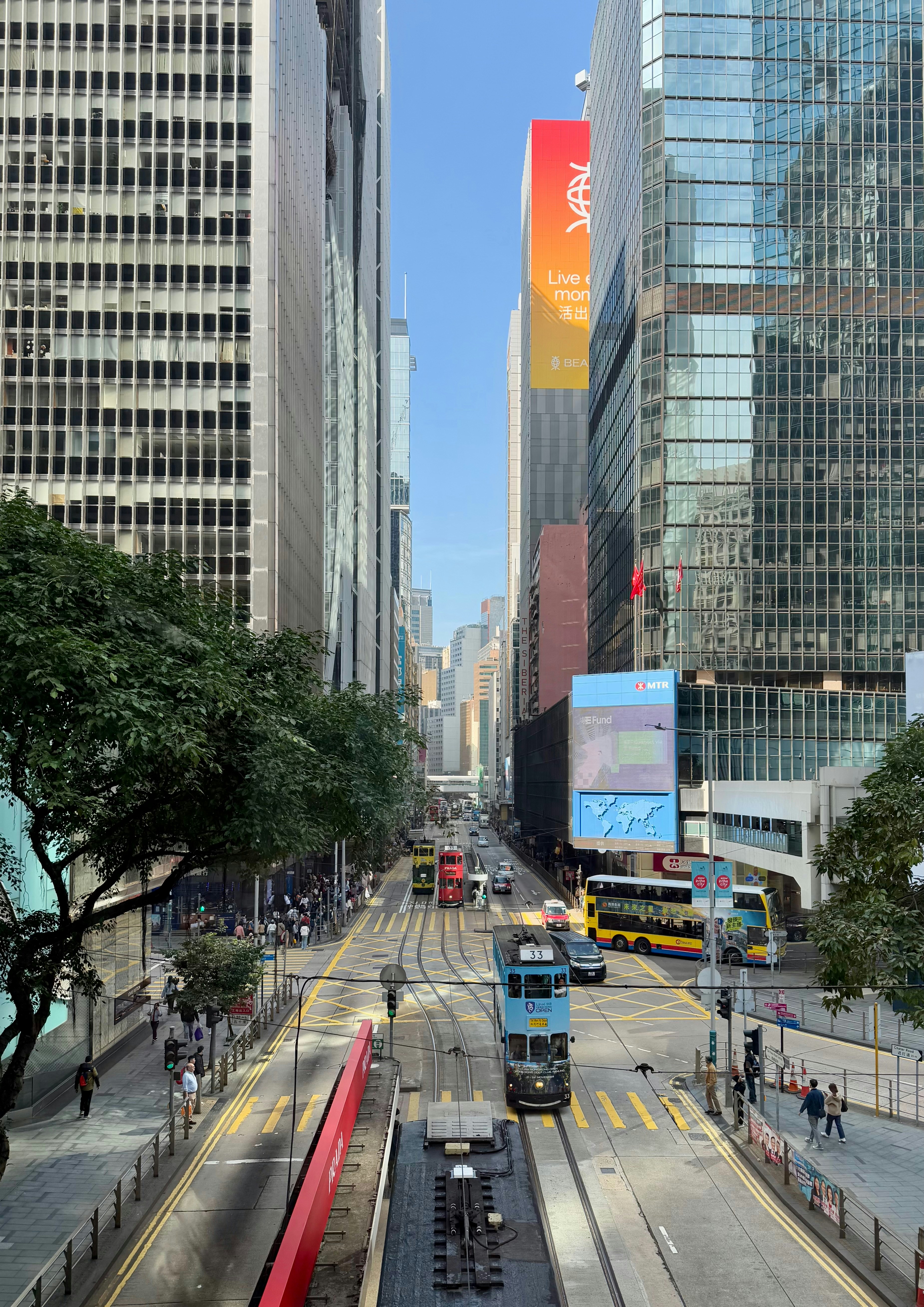 City street with tall buildings and a tram.