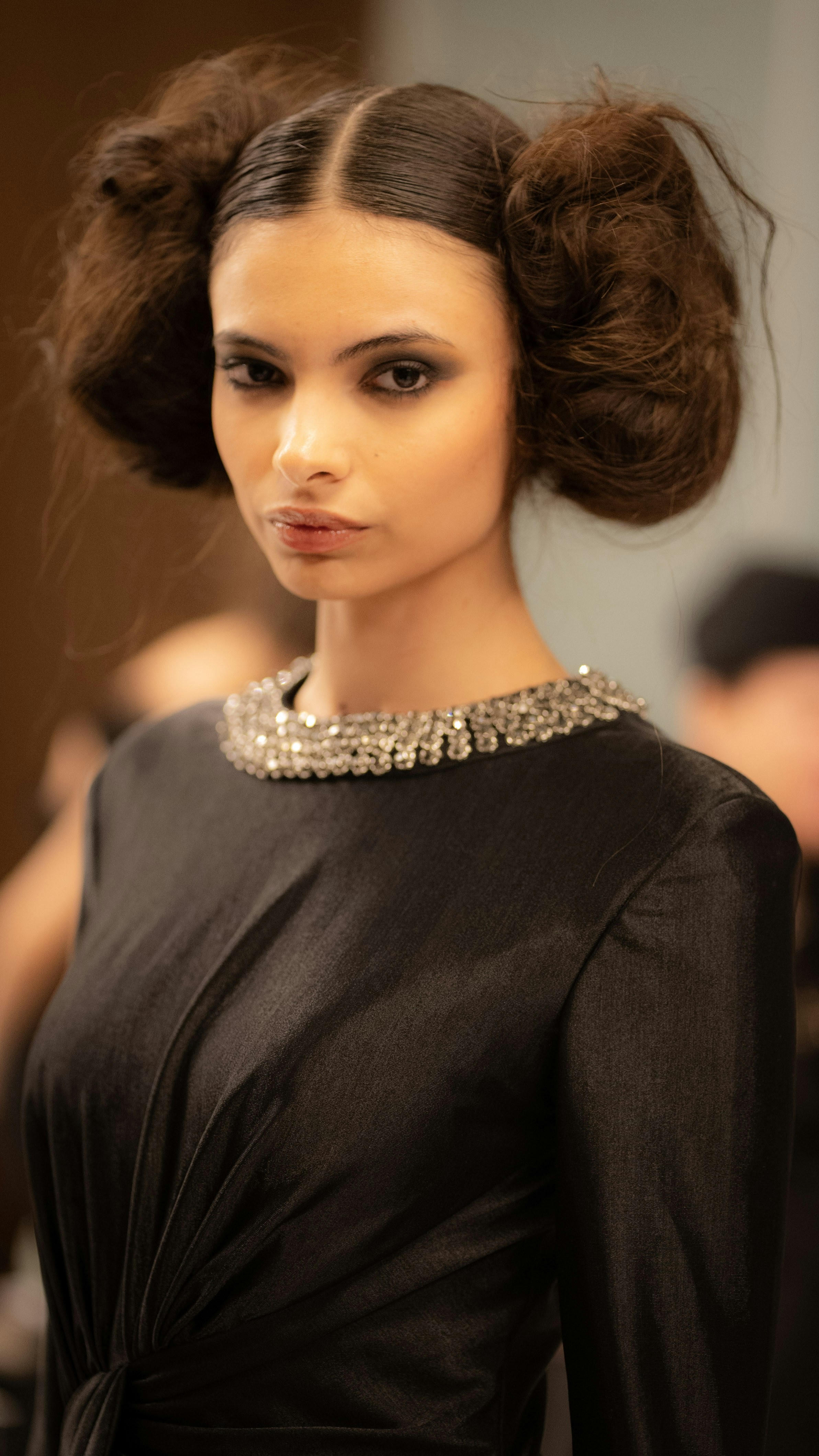 A woman posing, wearing a black dress.