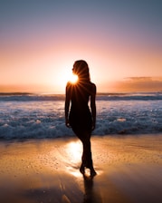 Woman watches the sunset over the ocean.