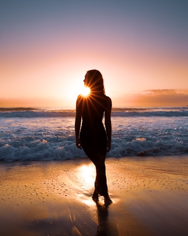 Woman watches the sunset over the ocean.