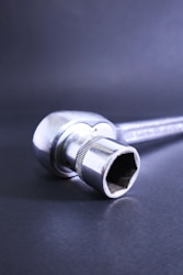 A socket wrench rests against a dark background.