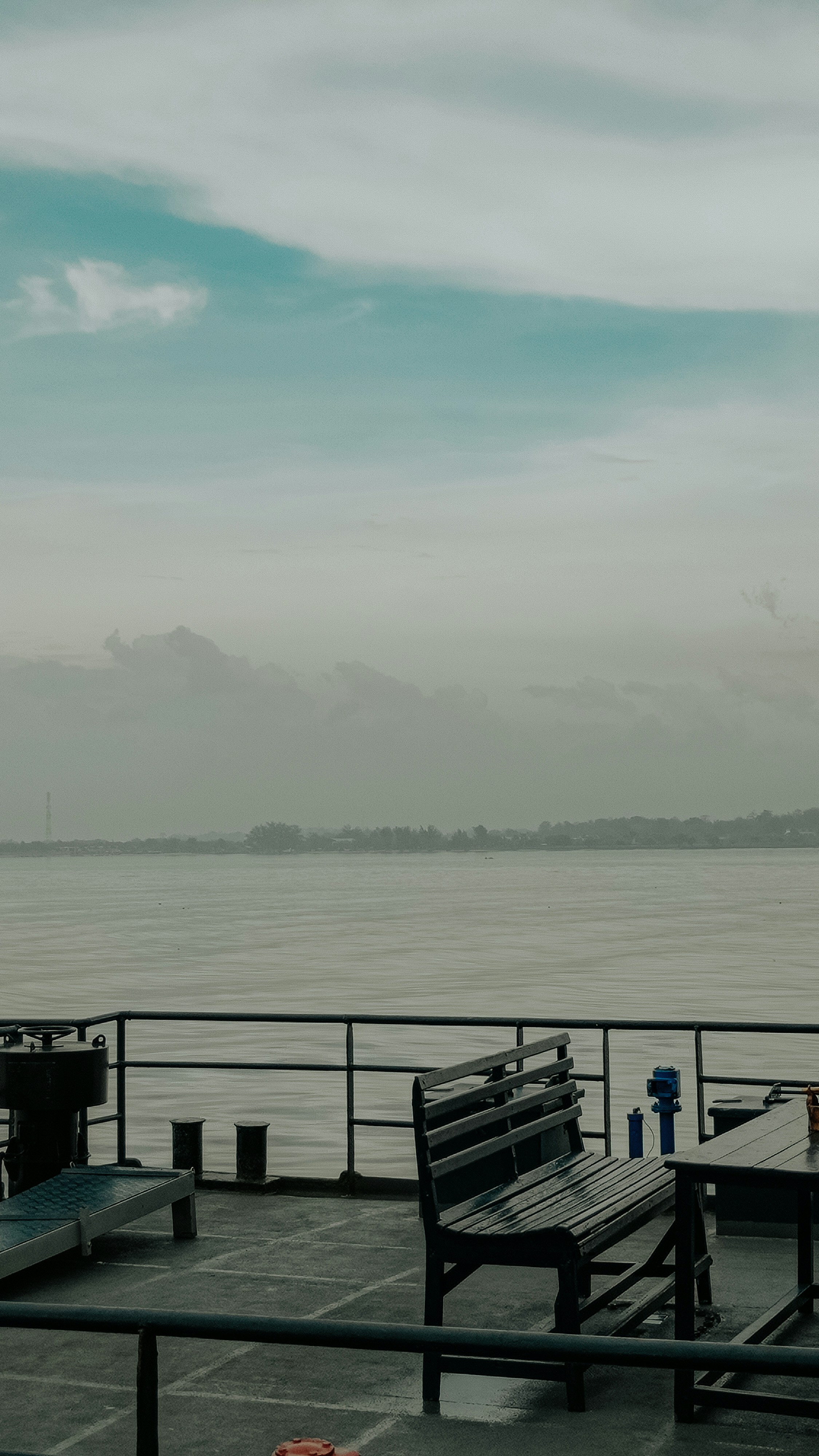 A bench on a deck overlooking the sea.