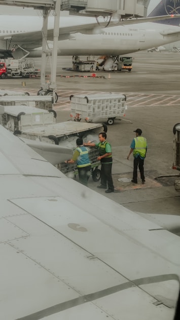 Ground crew loading baggage onto an airplane.
