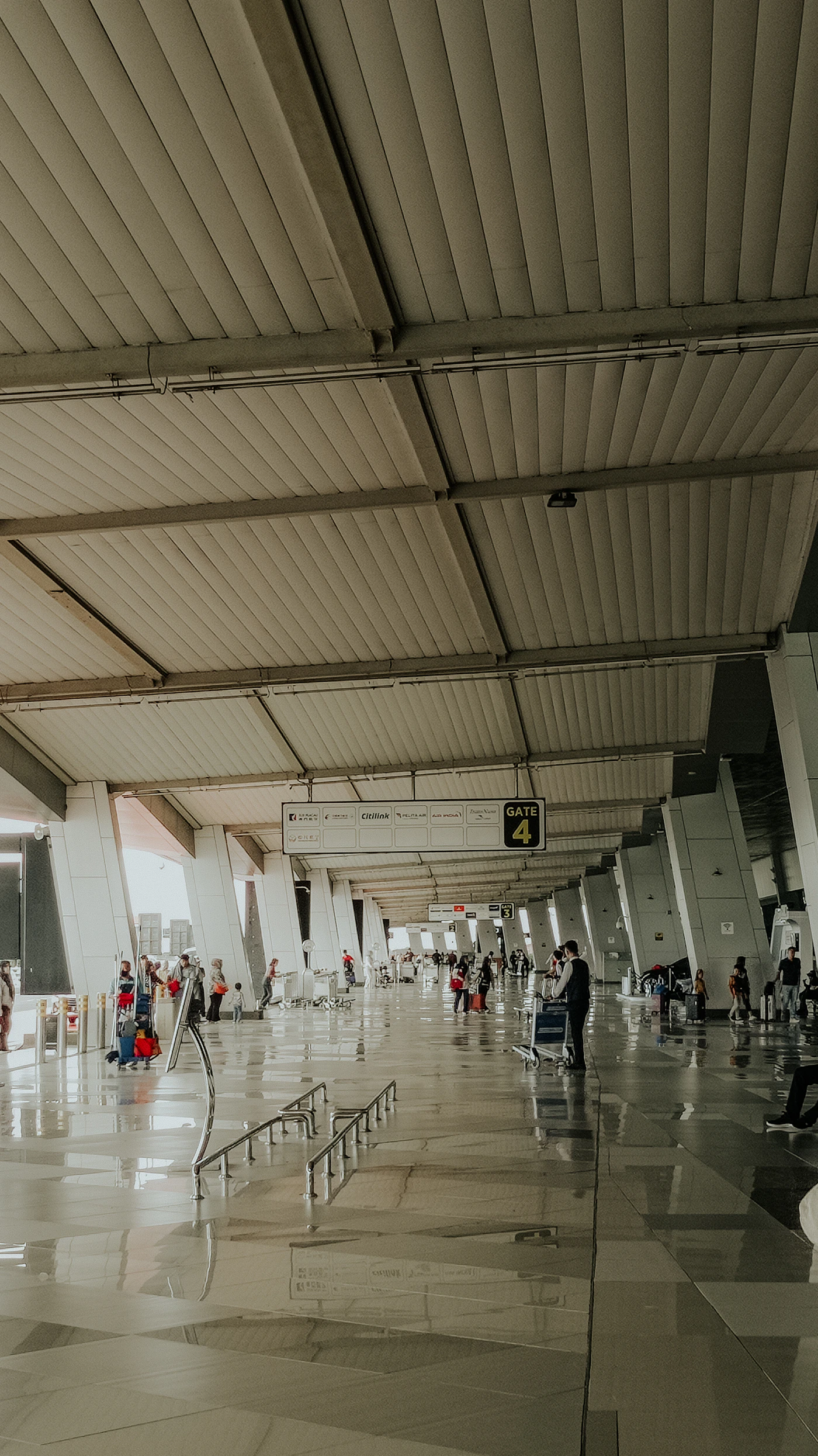 Travelers walking through a bright modern airport terminal before a flight