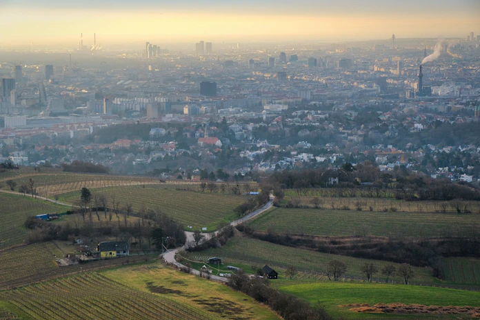 Rolling hills lead to a distant city.