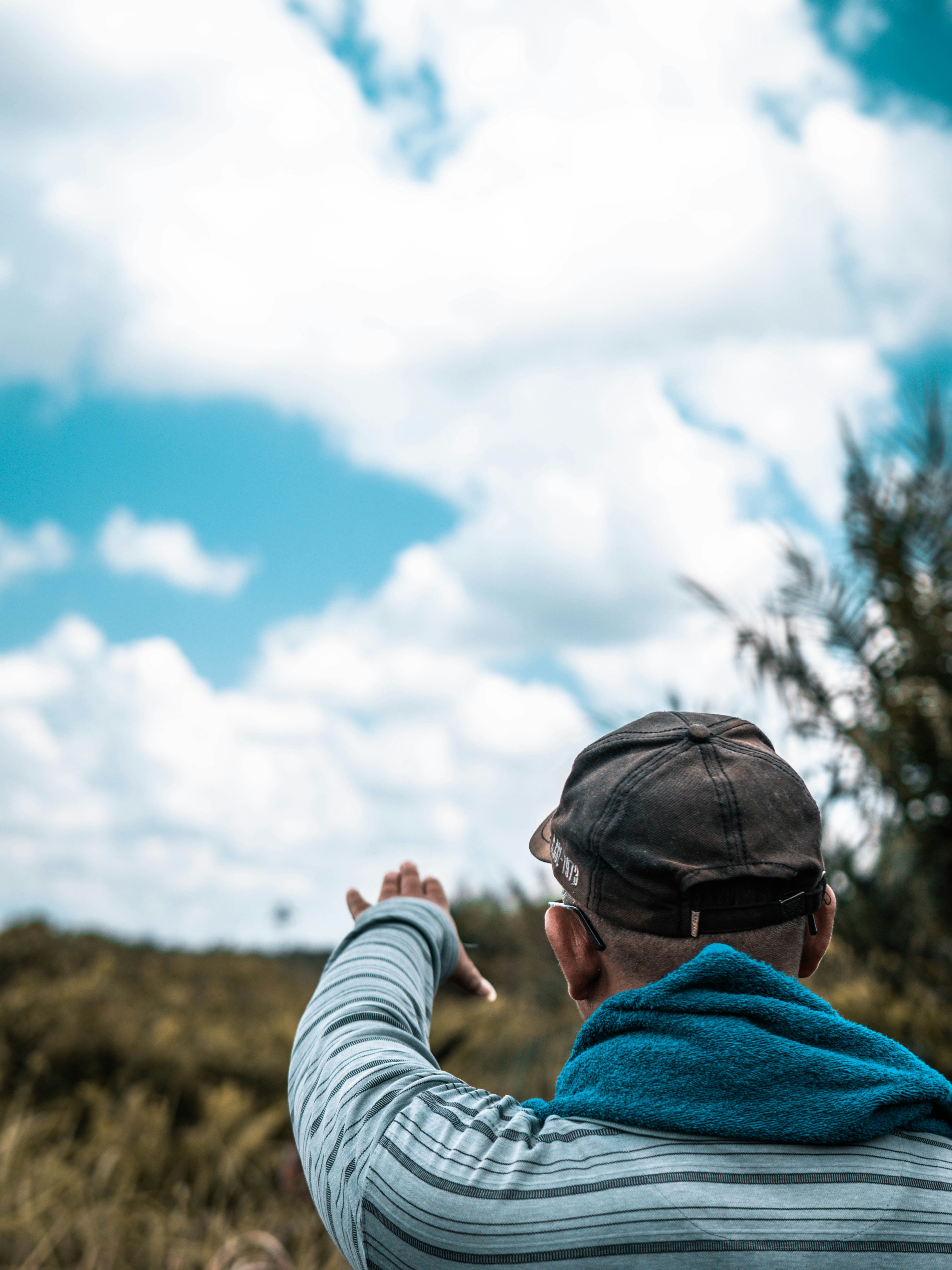 Person gazing upward at sky and clouds.