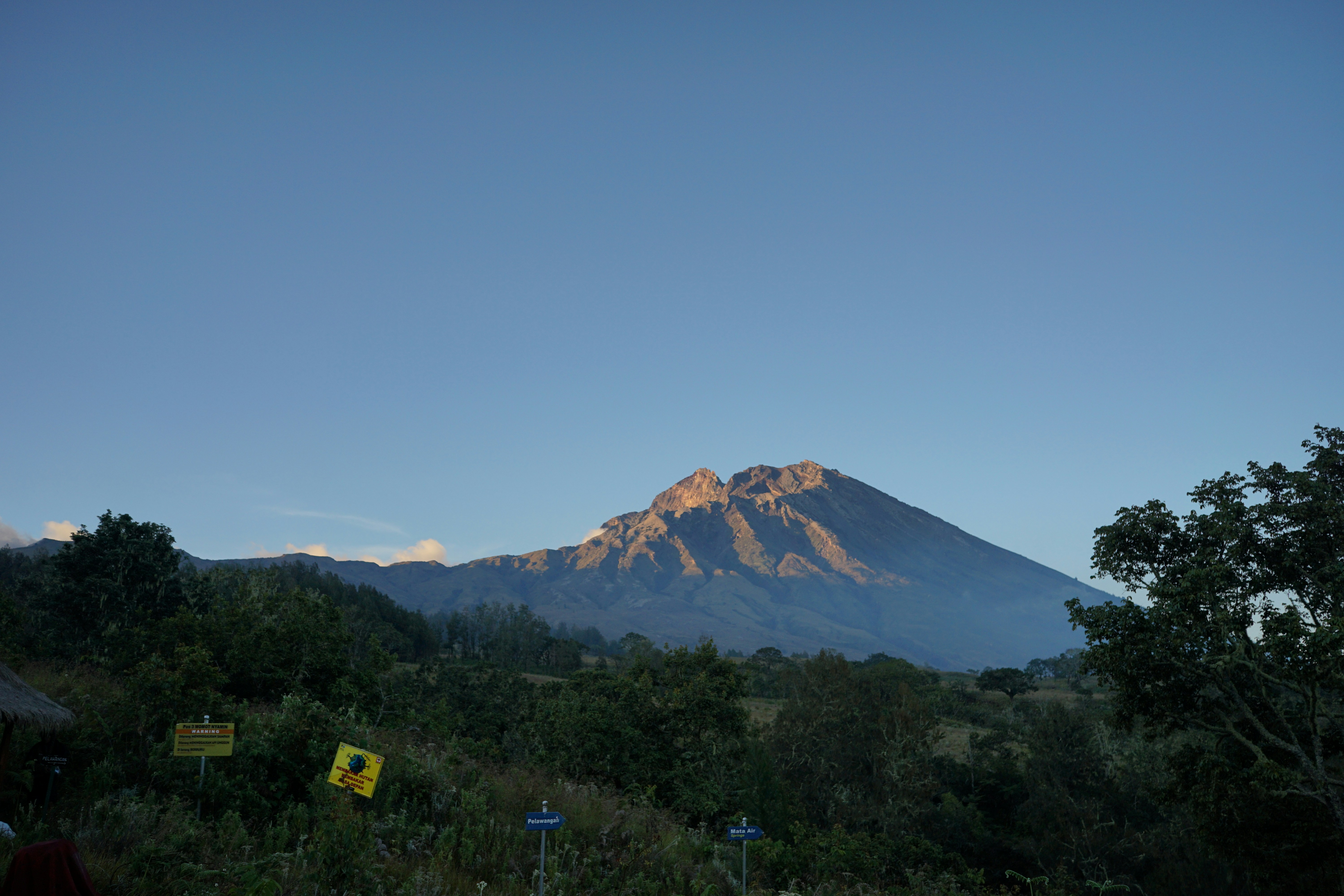 Sebuah gunung menjulang di langit biru yang cerah.