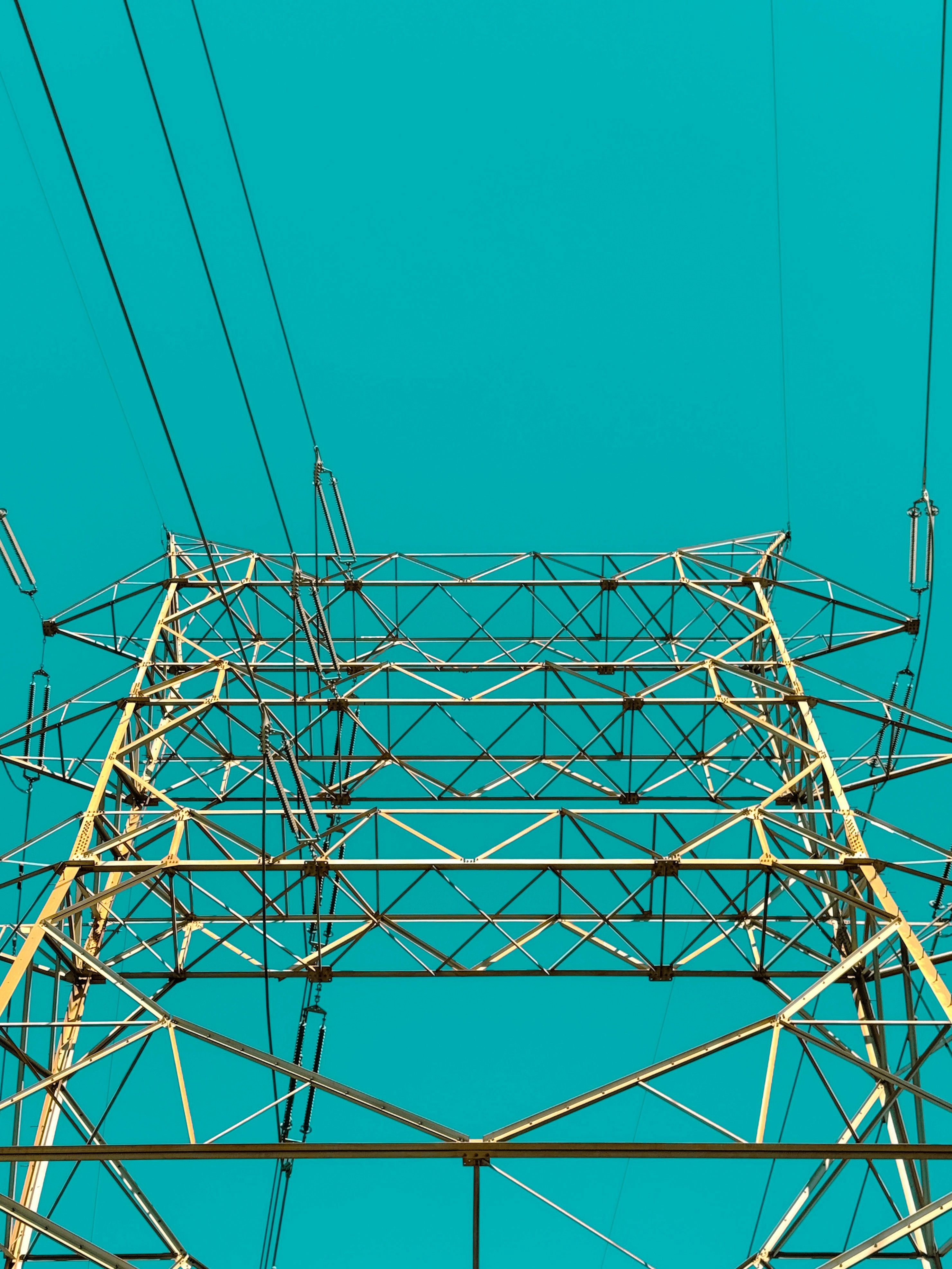 Power lines and tower against a bright blue sky.