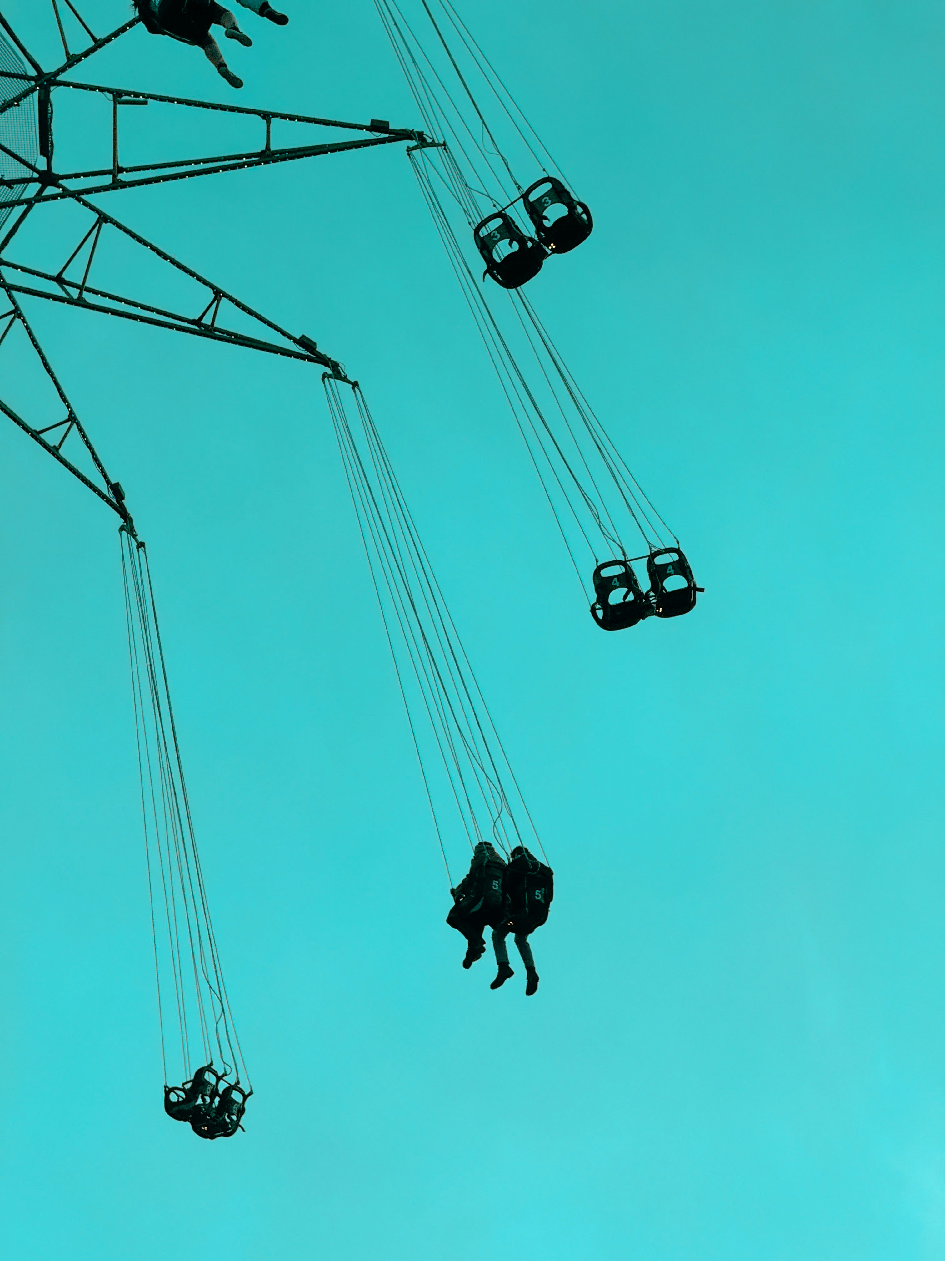 People ride a swing ride against a blue sky.