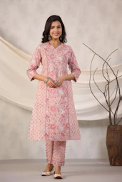 Woman poses in a pink floral kurta and pants.