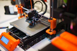 A 3D printer is shown in operation.