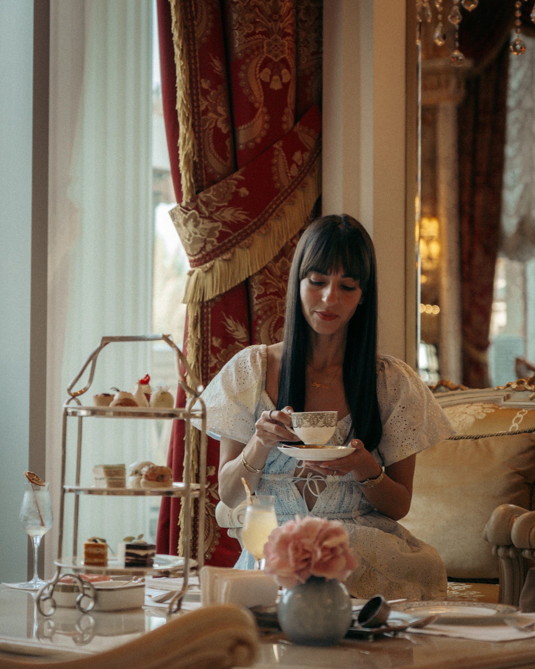 A woman taking afternoon tea in an elegant setting