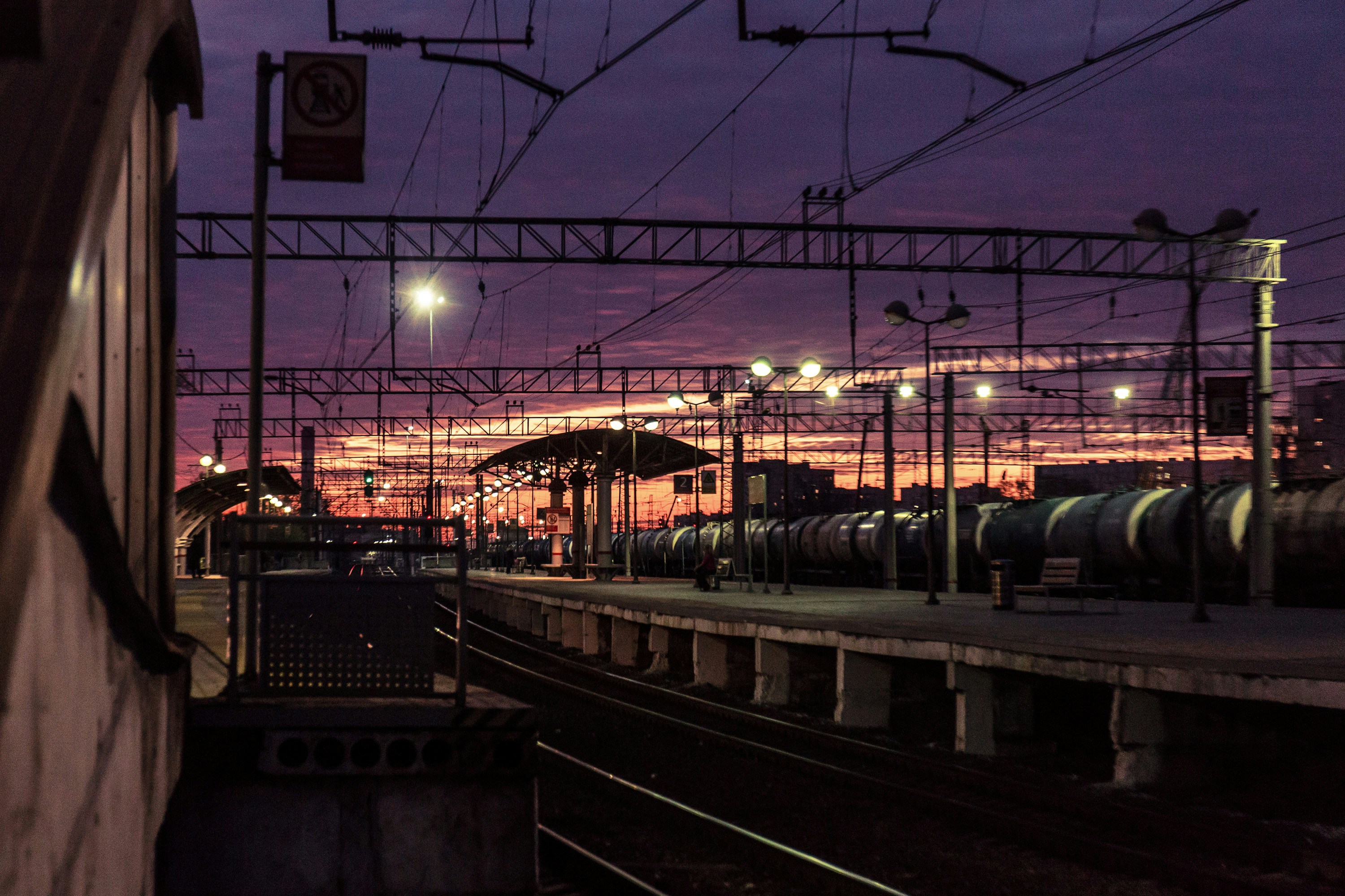 A train station illuminated by a vibrant sunset.