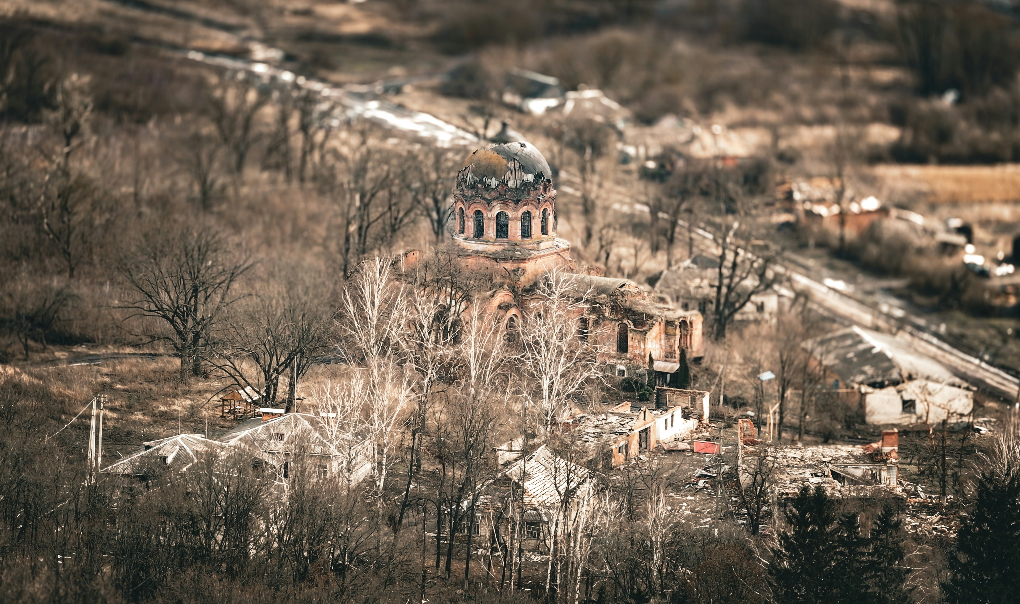 Old, abandoned building is surrounded by trees.