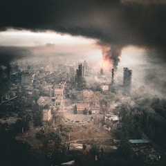 A devastated city burns under a smoky sky.
