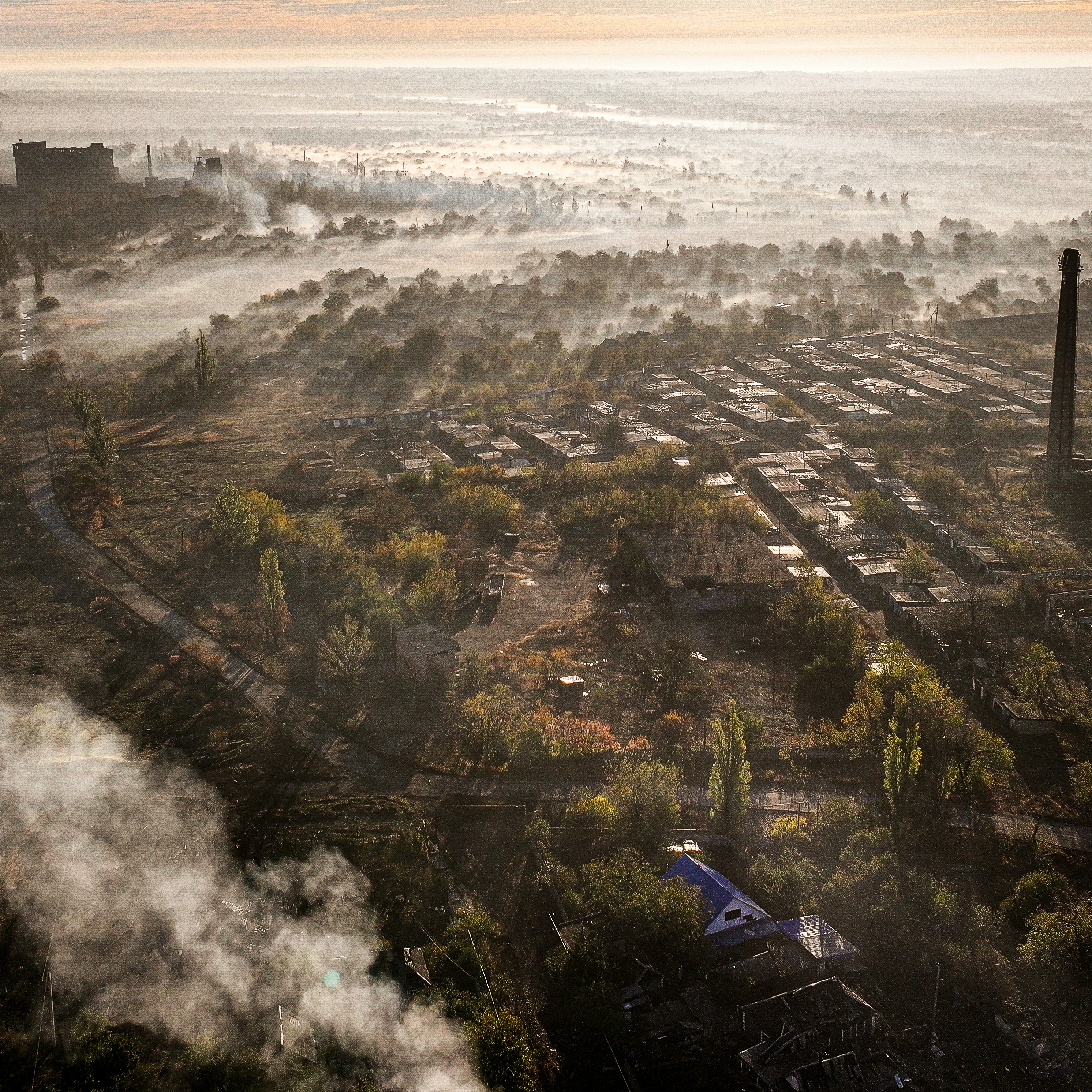 Overcast aerial view of a smoky industrial landscape.