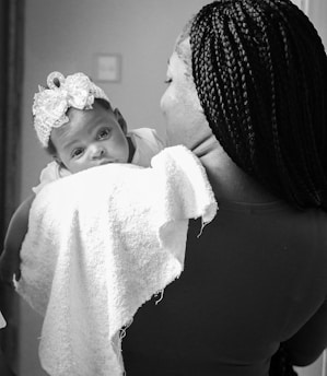 A mother lovingly holds her precious baby girl.