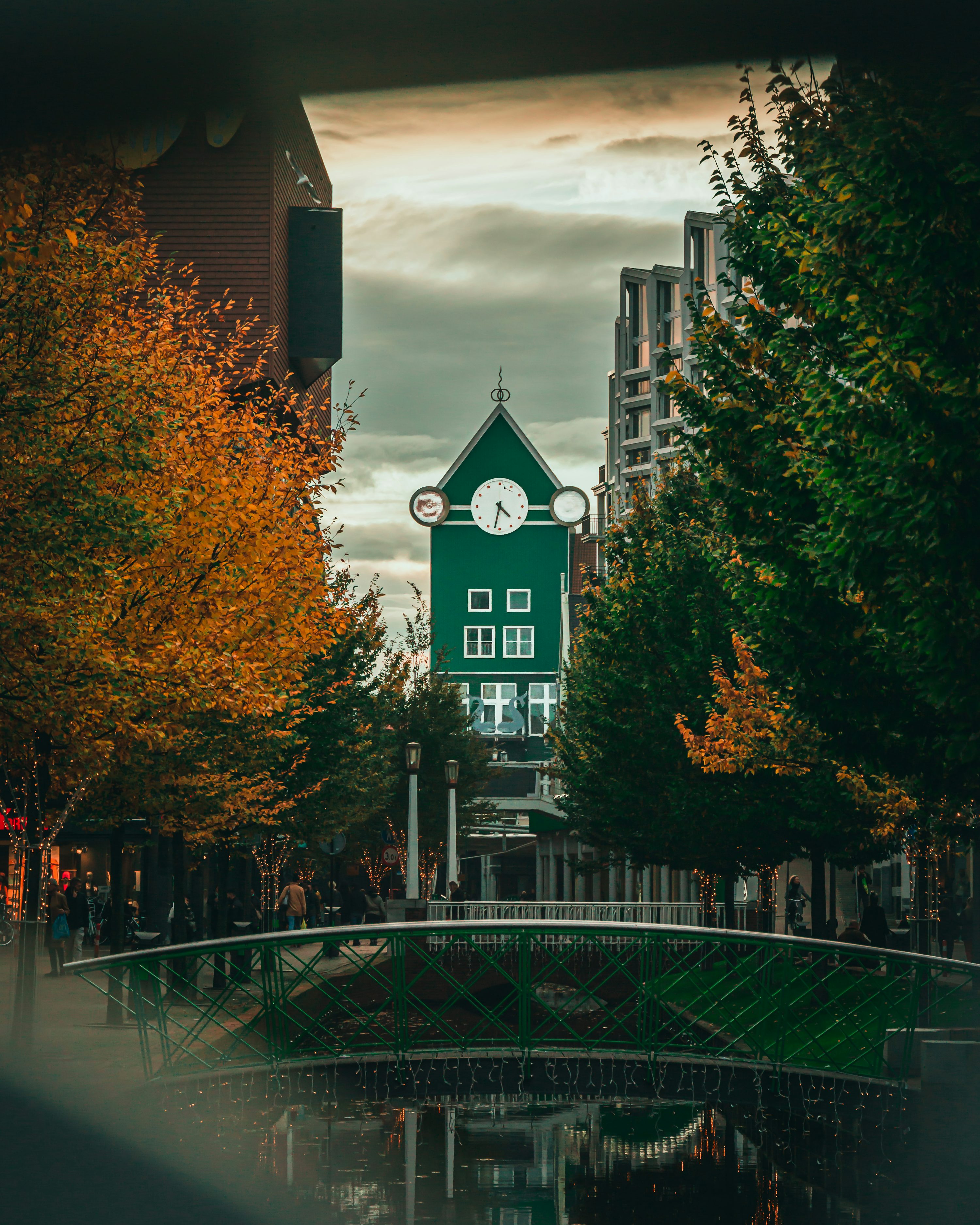 A green building stands amongst trees.