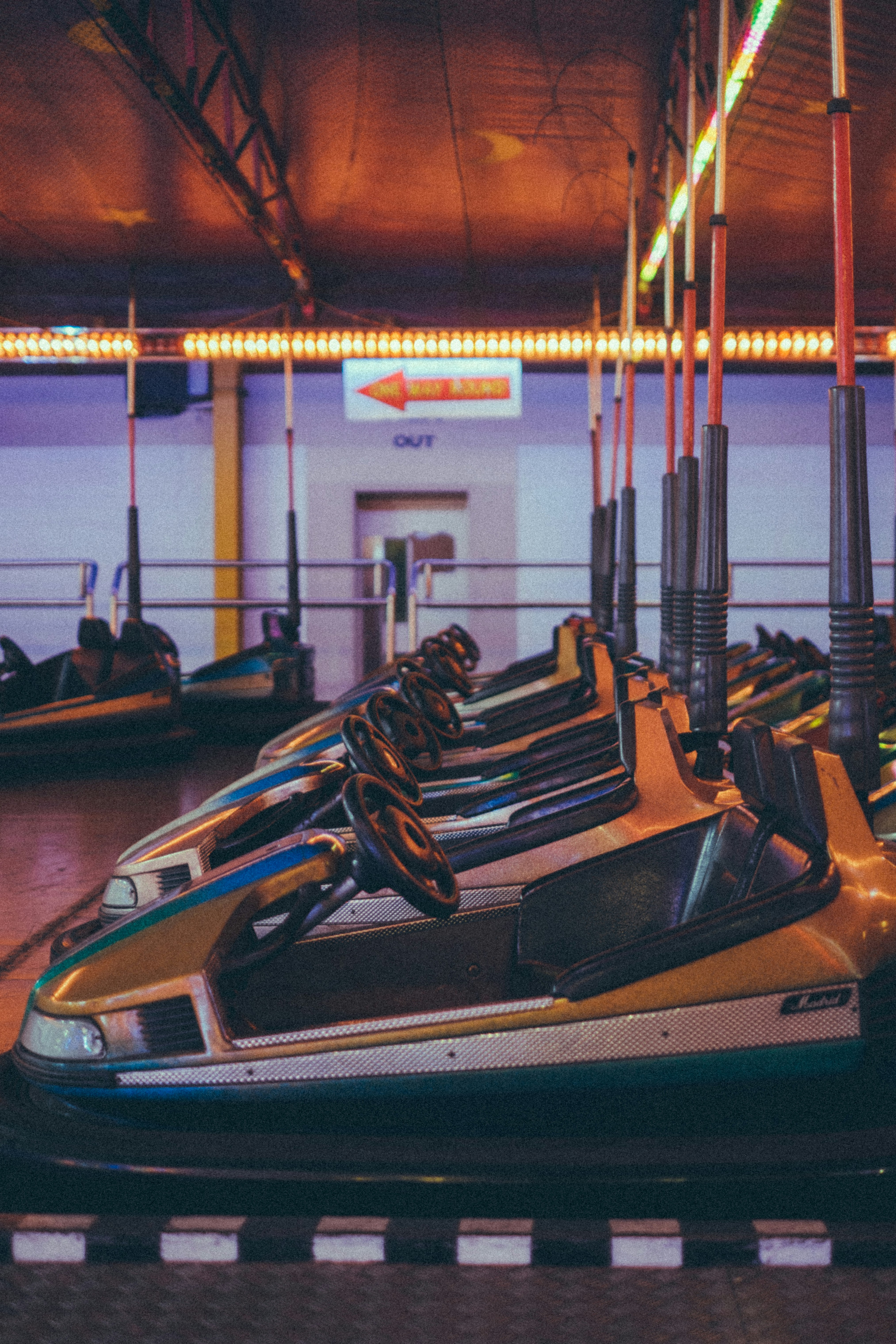 Bumper cars sit ready in an empty amusement park.